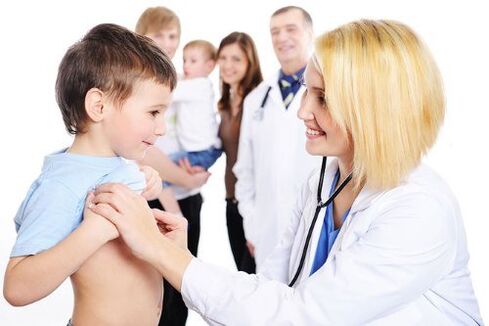 gydytojas apžiūri vaiką su kirmėlėmis